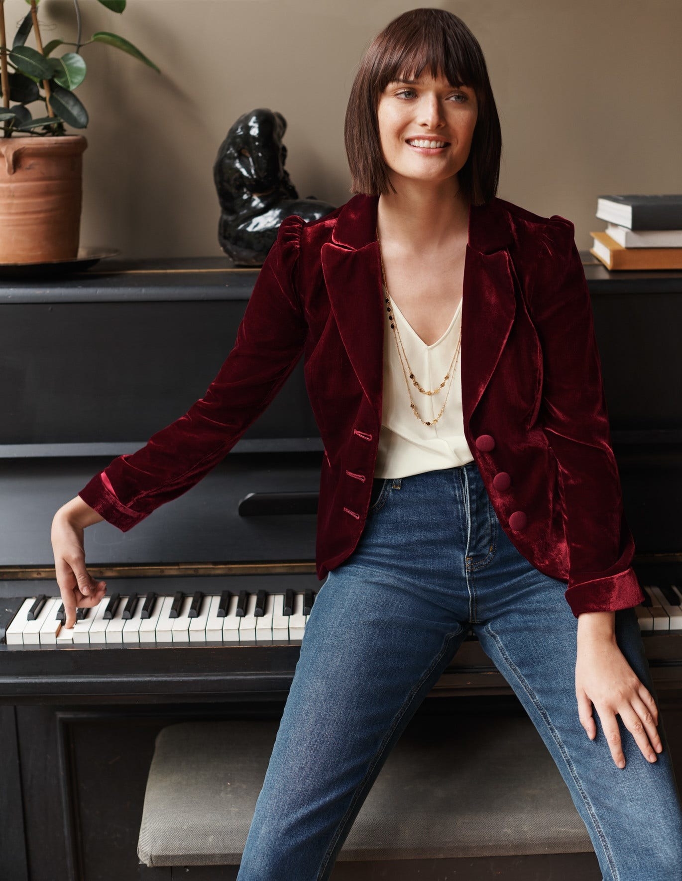 Model in a maroon velvet blazer with puff sleeves and three thick buttons