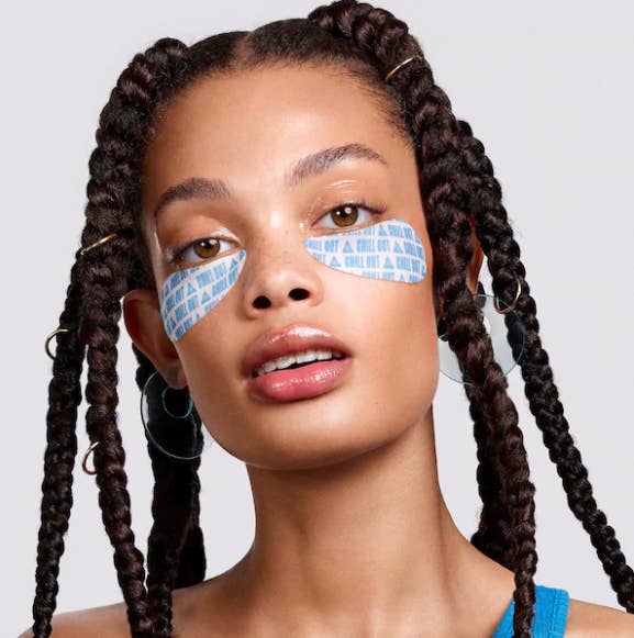 A person looking into the camera while wearing the under-eye patches