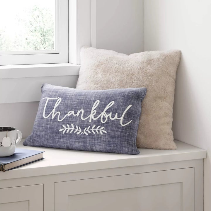 The pillow placed behind a smaller pillow on a window seat