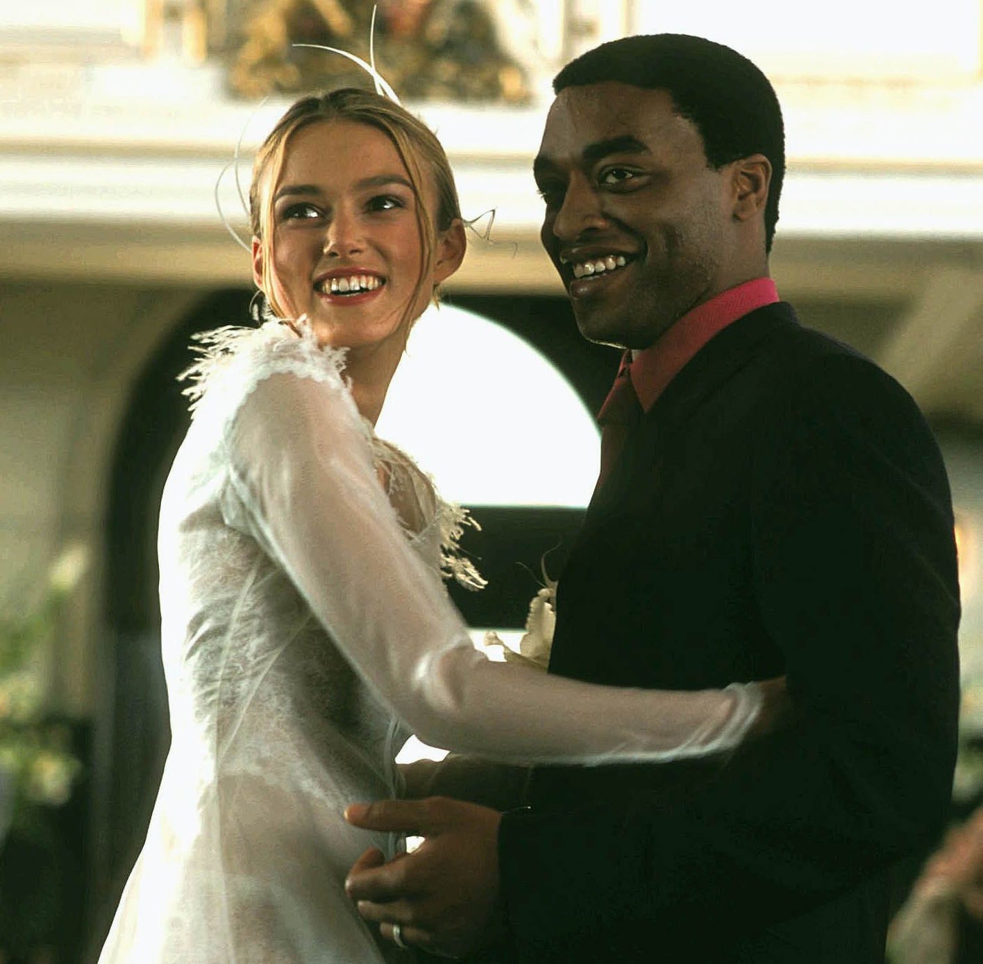 Still from Love Actually: Keira Knightley and Chiwetel Ejiofor wear wedding clothes and stand close together, smiling