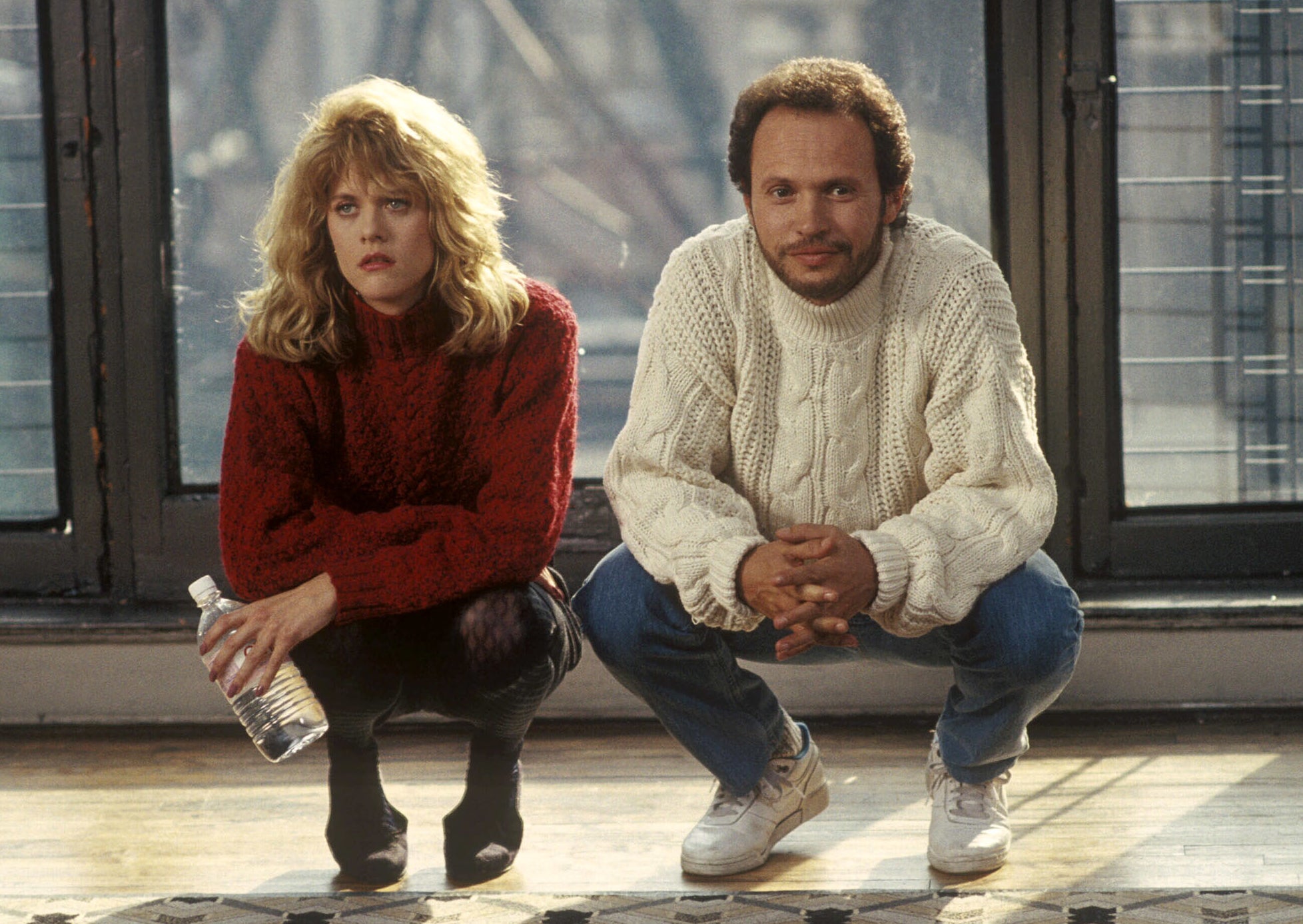 Still from When Harry Met Sally: Meg Ryan and Billy Crystal squat side by side, smiling at each other