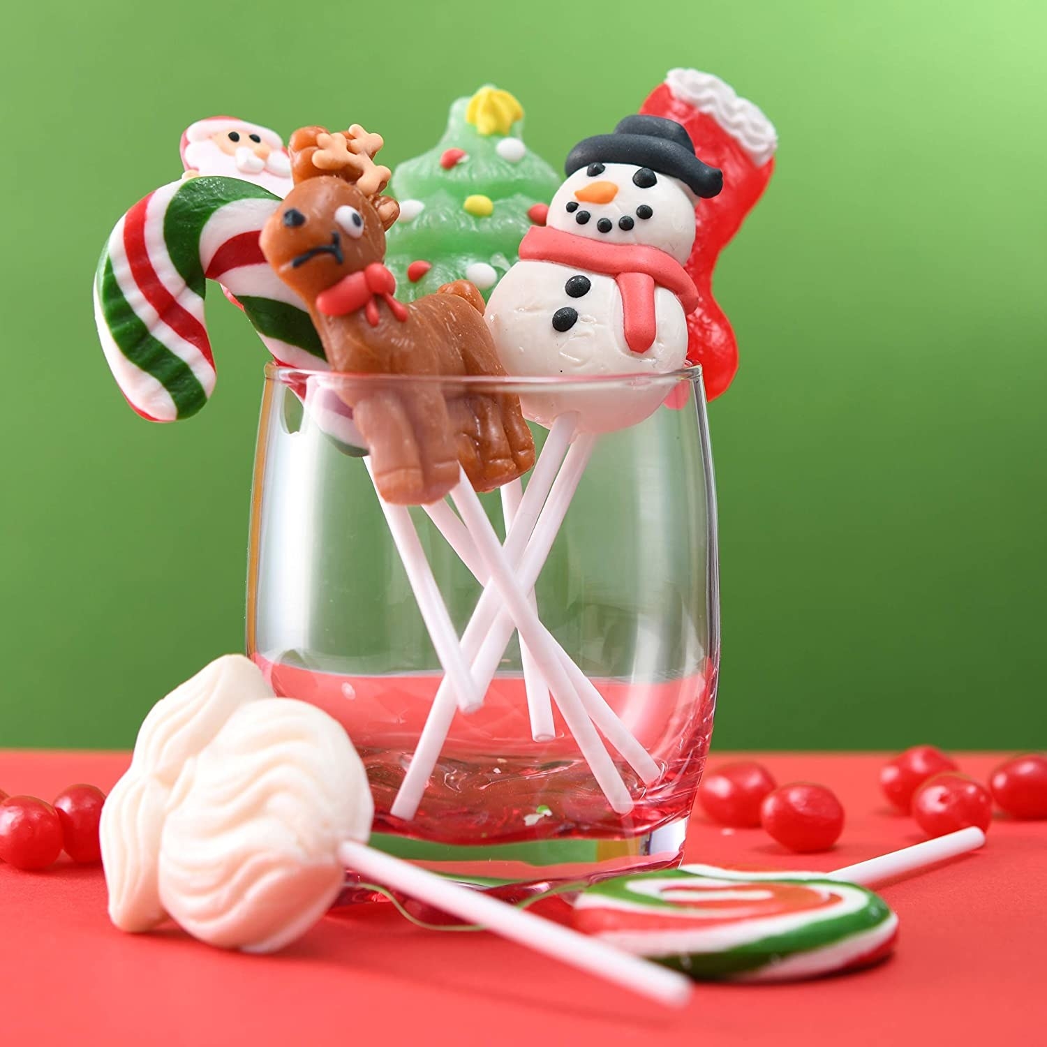 Several suckers in Christmas shapes like Santa, his beard, snowman, and reindeer inside mason jar 