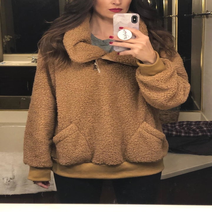 reviewer wearing sweater in brown 