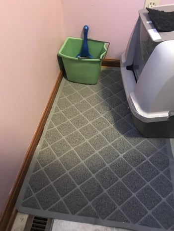 a grey litter mat under a hooded litter box