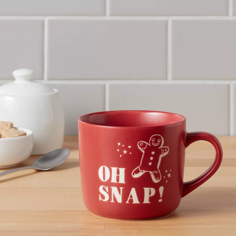 The red mug with a gingerbread man on it and the words &quot;oh snap!&quot;