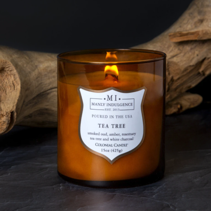 A close-up of the Tea Tree-scented candle, sitting next to a log