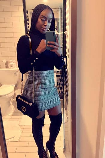 A reviewer wearing the black and white fitted skirt with over the knee boots
