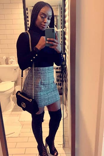 A reviewer wearing the black and white fitted skirt with over the knee boots