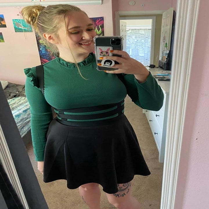 A reviewer wearing the top in green 