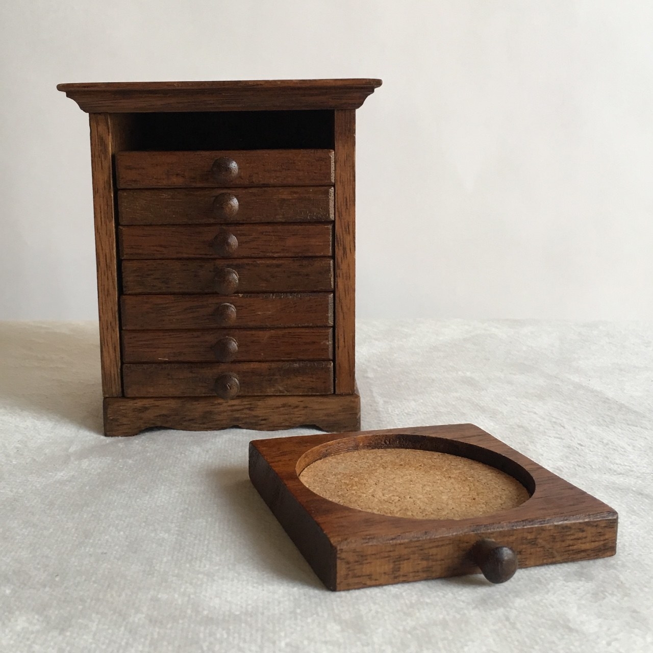 Vintage wooden coasters with cork and the small cabinet they fit into