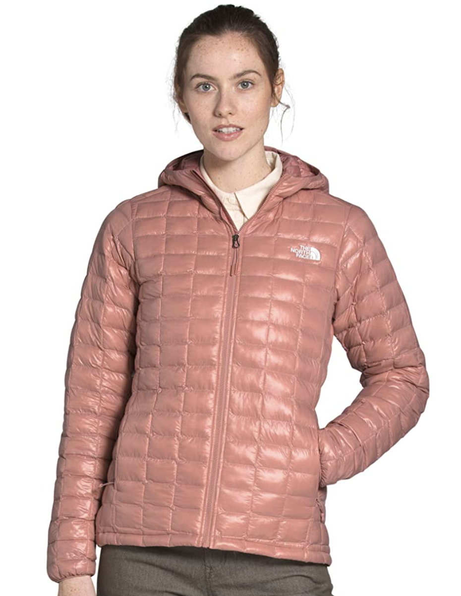 Model wears The North Face insulated hooded jacket in pink clay