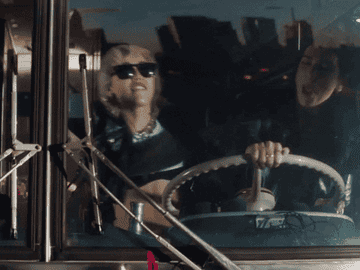 Miley and Dua Lipa driving a bus