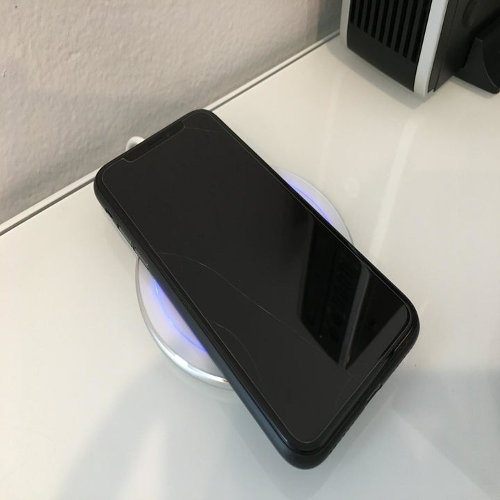 White wireless charger with phone placed on top