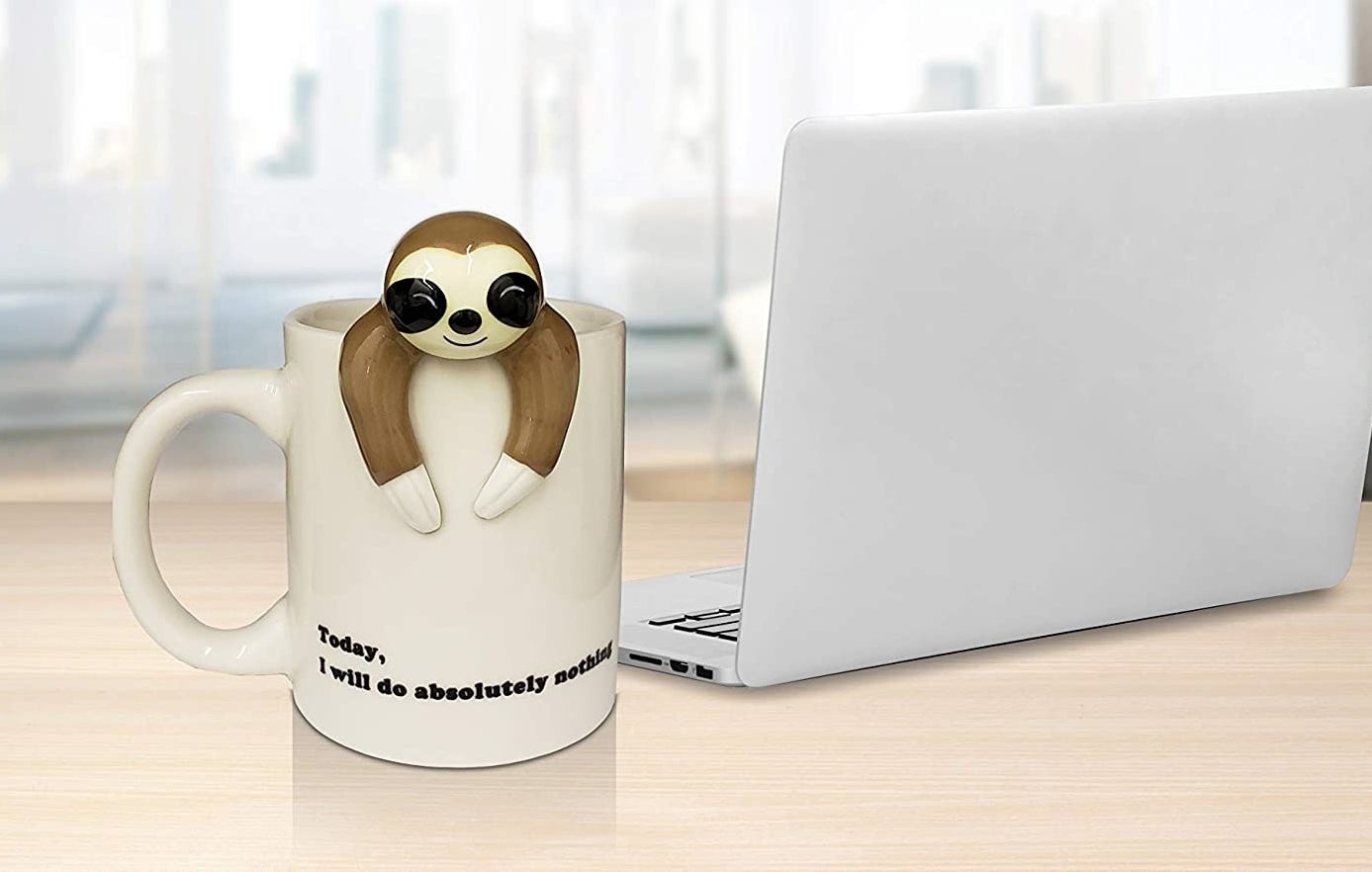 Coffee mug with sloth-shaped figure attached on the edge