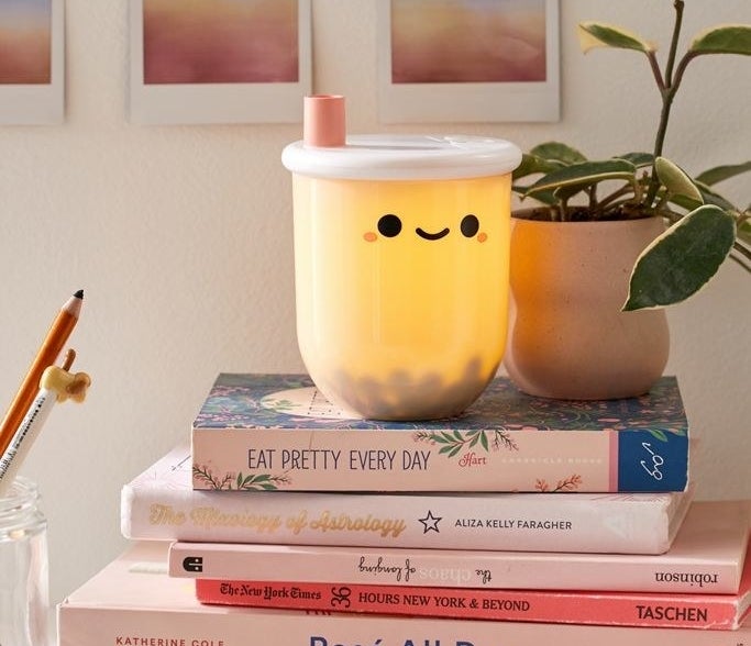 Mini boba tea-shaped lamp placed on a stack of books