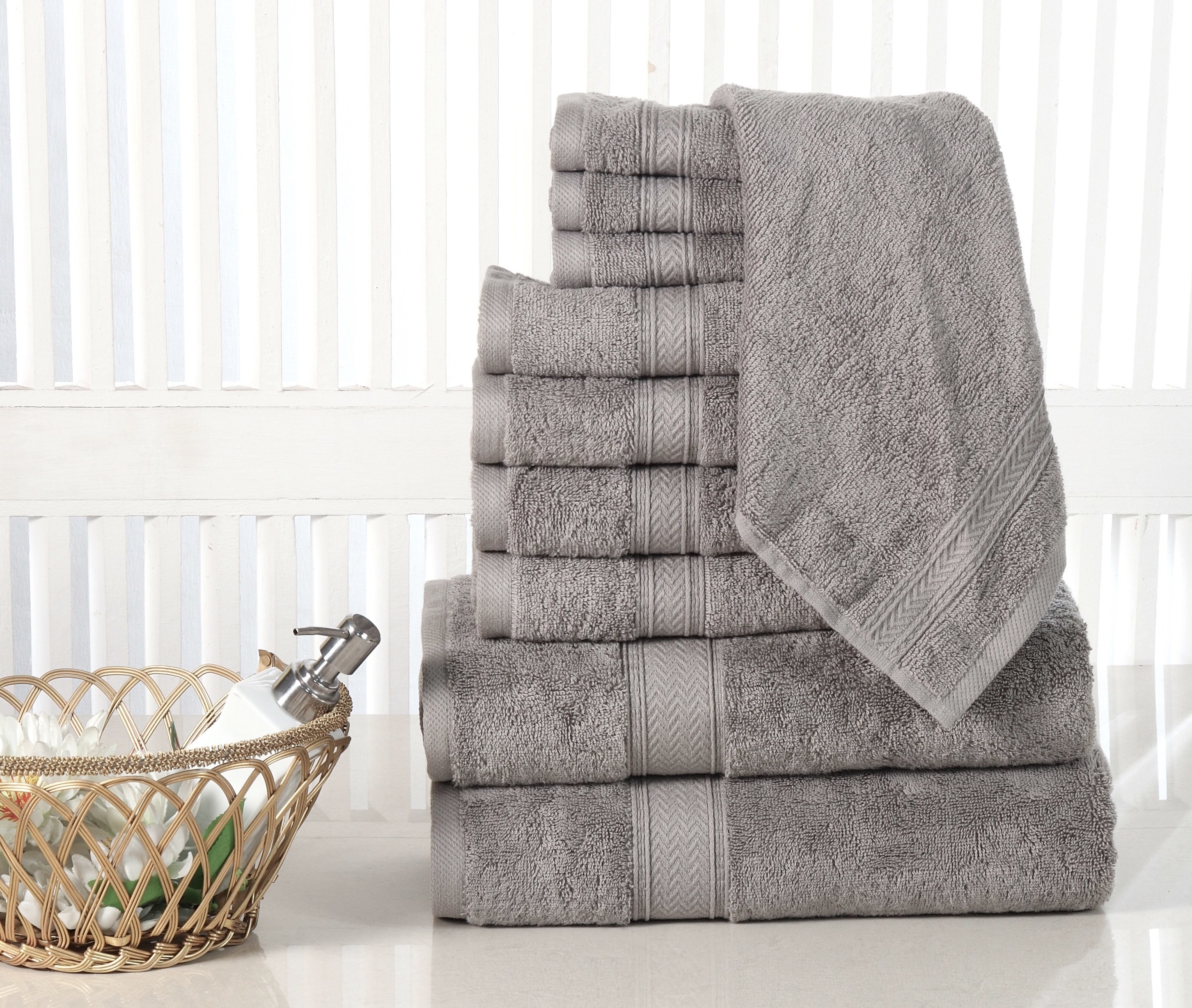 the towel set folded neatly in the bathroom in the color grey