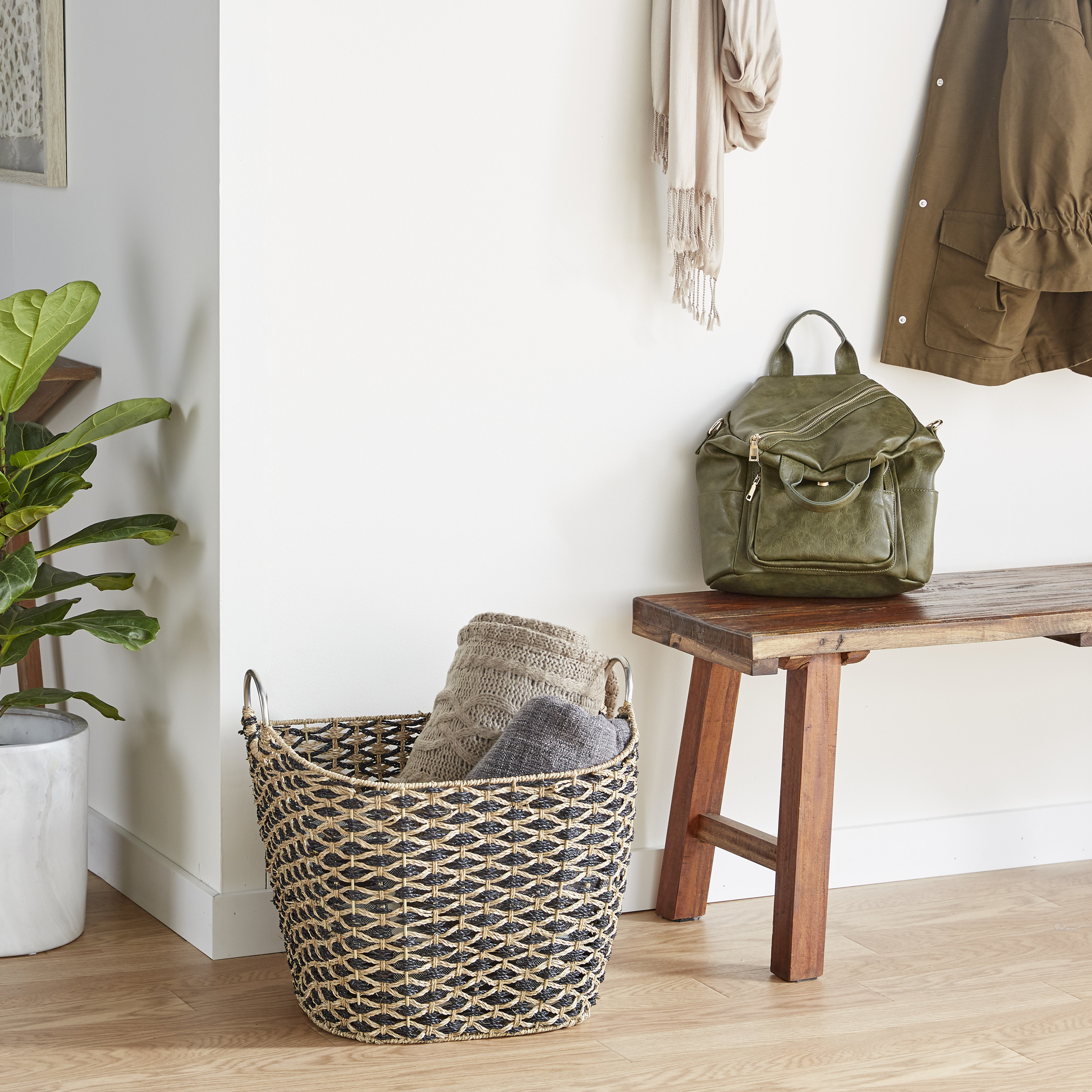 the wicker storage basket displayed next to a wooden bench with blankets inside of it