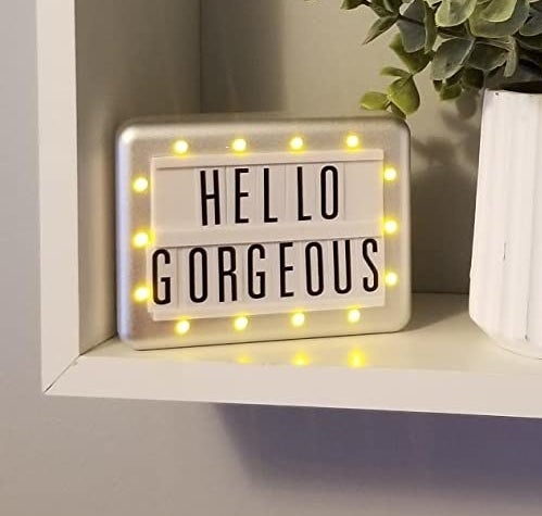 Light-up marquee with the words "Hello Gorgeous" placed on shelf