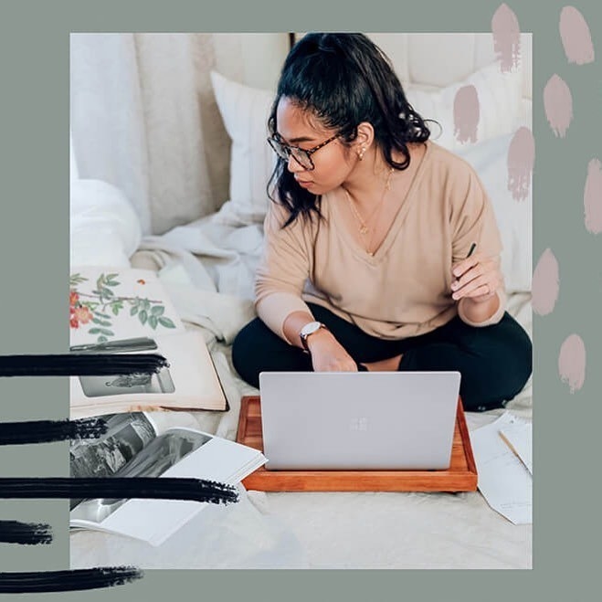 a girl on her bed, studying on her laptop with books 