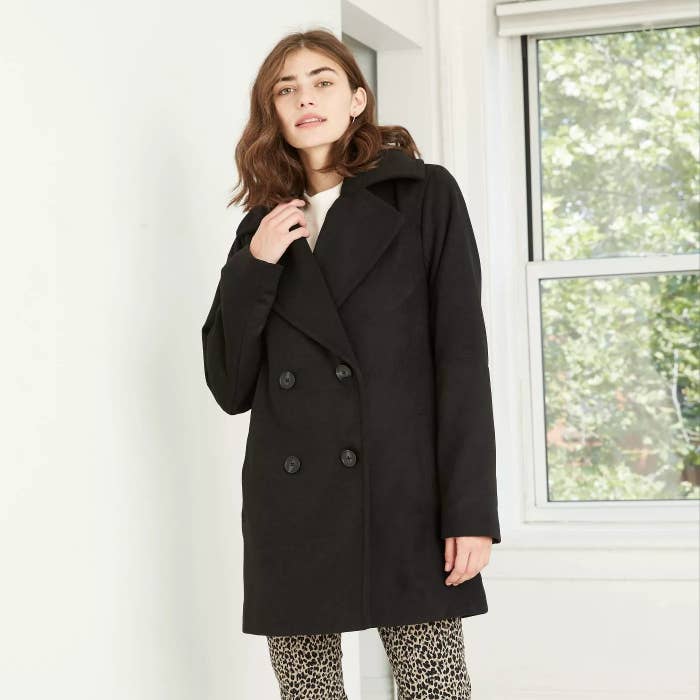 A short black coat with buttons paired with cheetah pants.