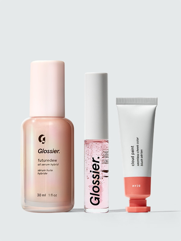 The Dewy Look trio set with a bottle of Futuredew, a clear container of Lip Gloss, and a pink and white container of Beam Cloud Paint