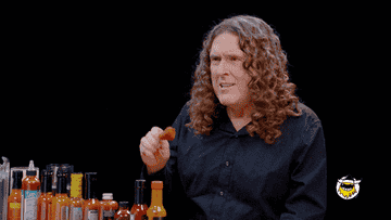 Weird Al eating a hot chicken wing and liking it