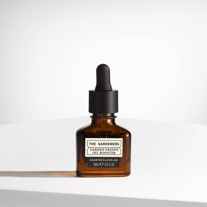the small glass bottle of garden greens oil booster on a white countertop 