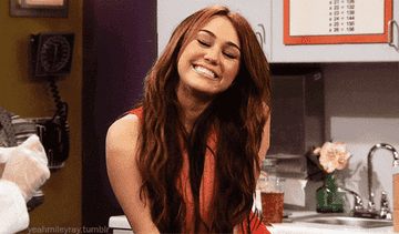 Miley Cyrus smiling and fluttering eyelashes