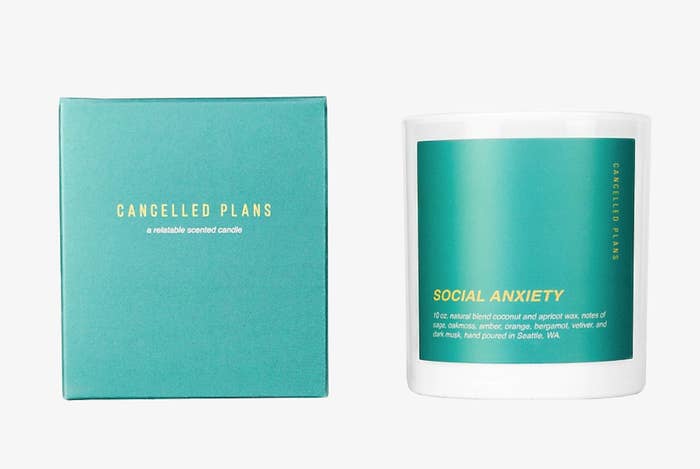 A teal-colored candle that says &quot;social anxiety&quot; on it