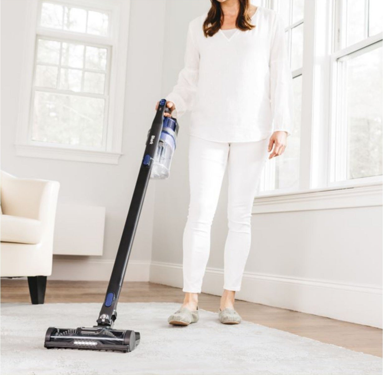 A model using the stick vacuum vacuum on a carpet 