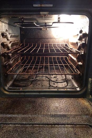 Reviewer photo of their dirty oven interior with lots of baked-on food bits 