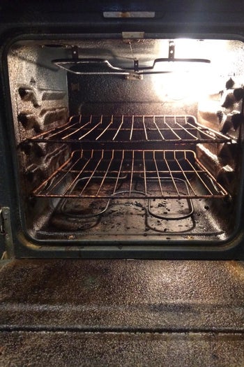 Reviewer photo of their dirty oven interior with lots of baked-on food bits 