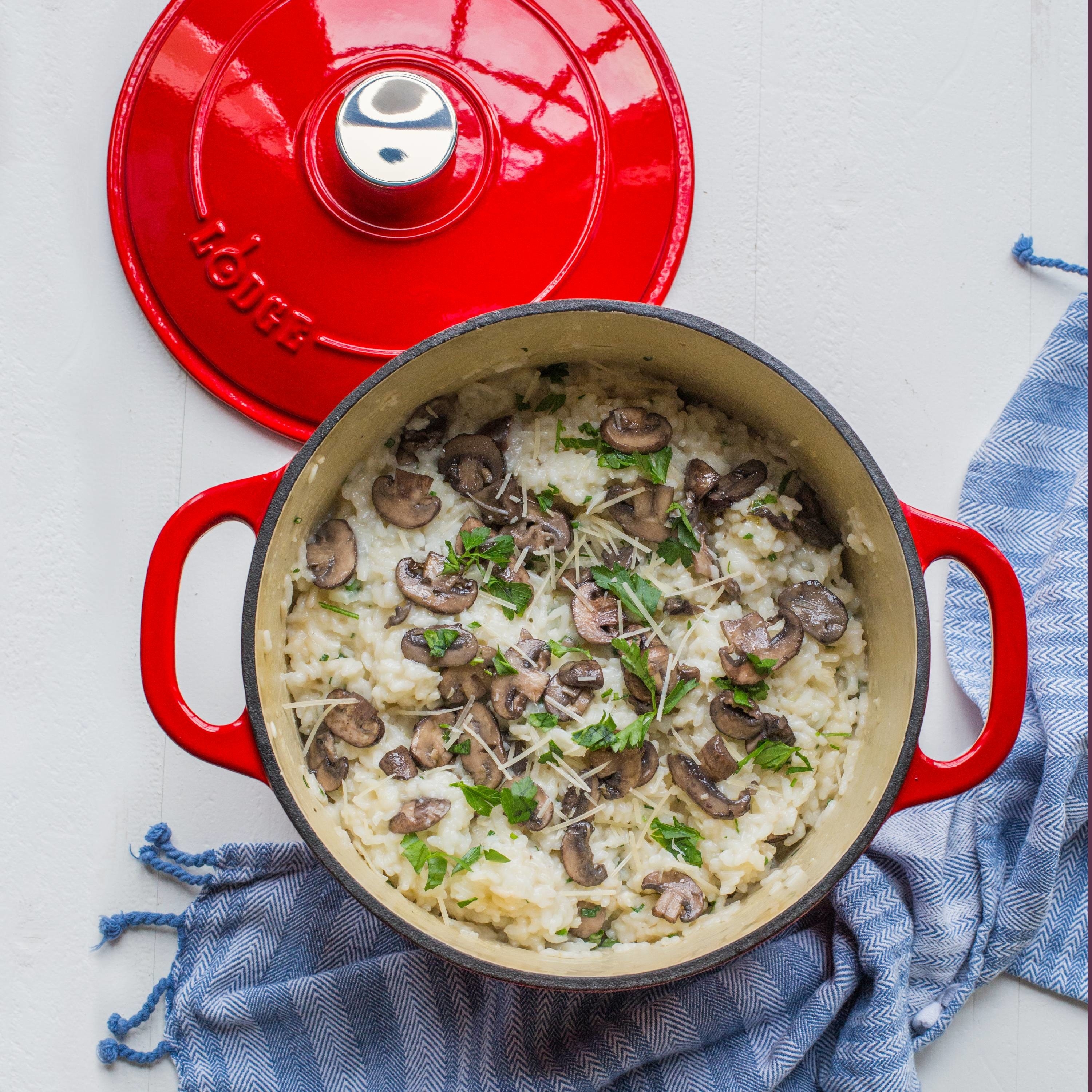 the dutch oven in red with a mushroom risotto inside