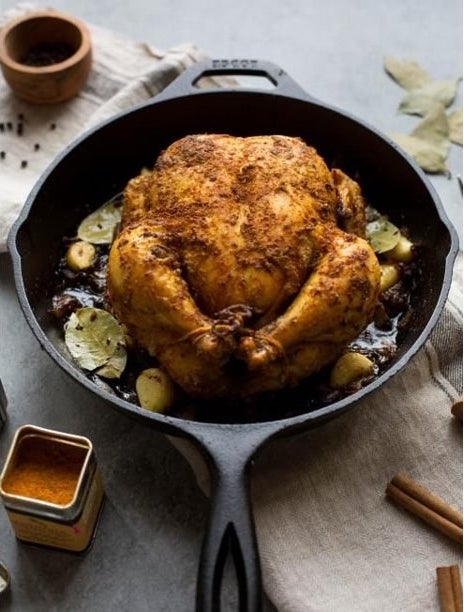 The cast iron skillet with chicken in it 