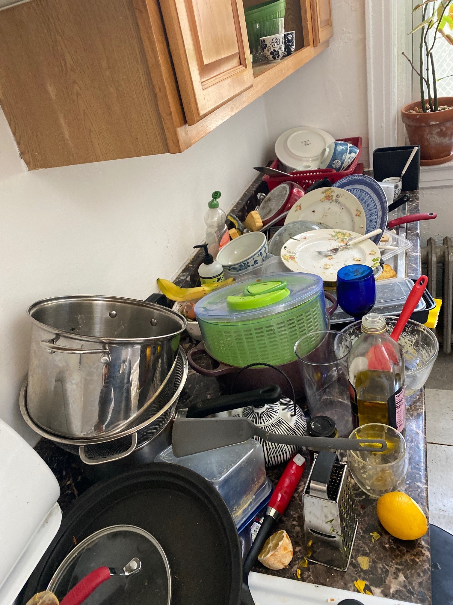 A massive amount of dirty dishes are strewn across a countertop