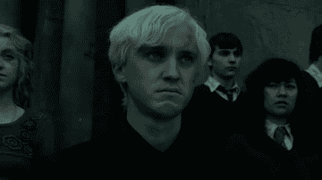 Draco looking distraught among his fellow Hogwarts students 