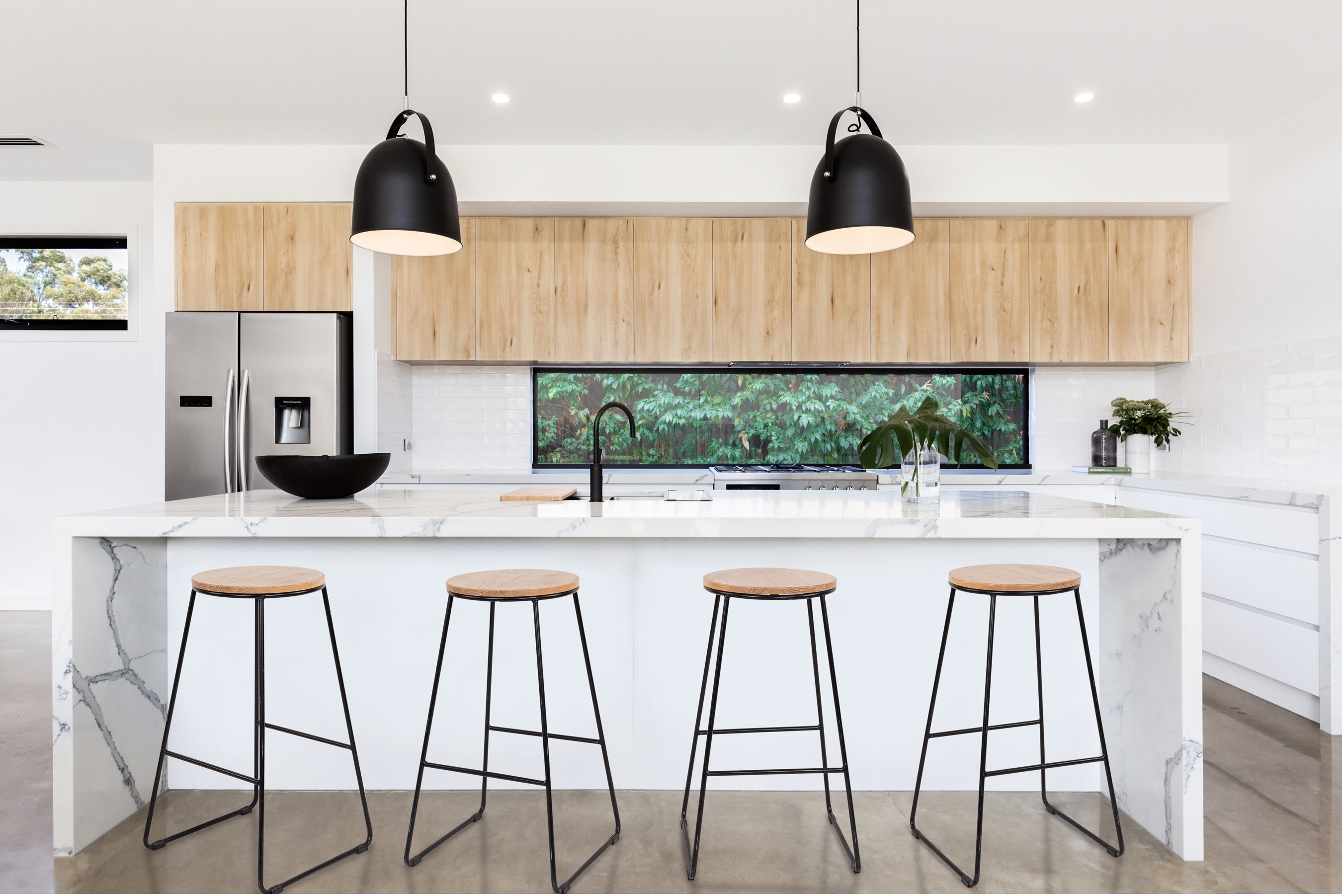 the four stools with a black metal bottom and round wood top displayed in a kitchen