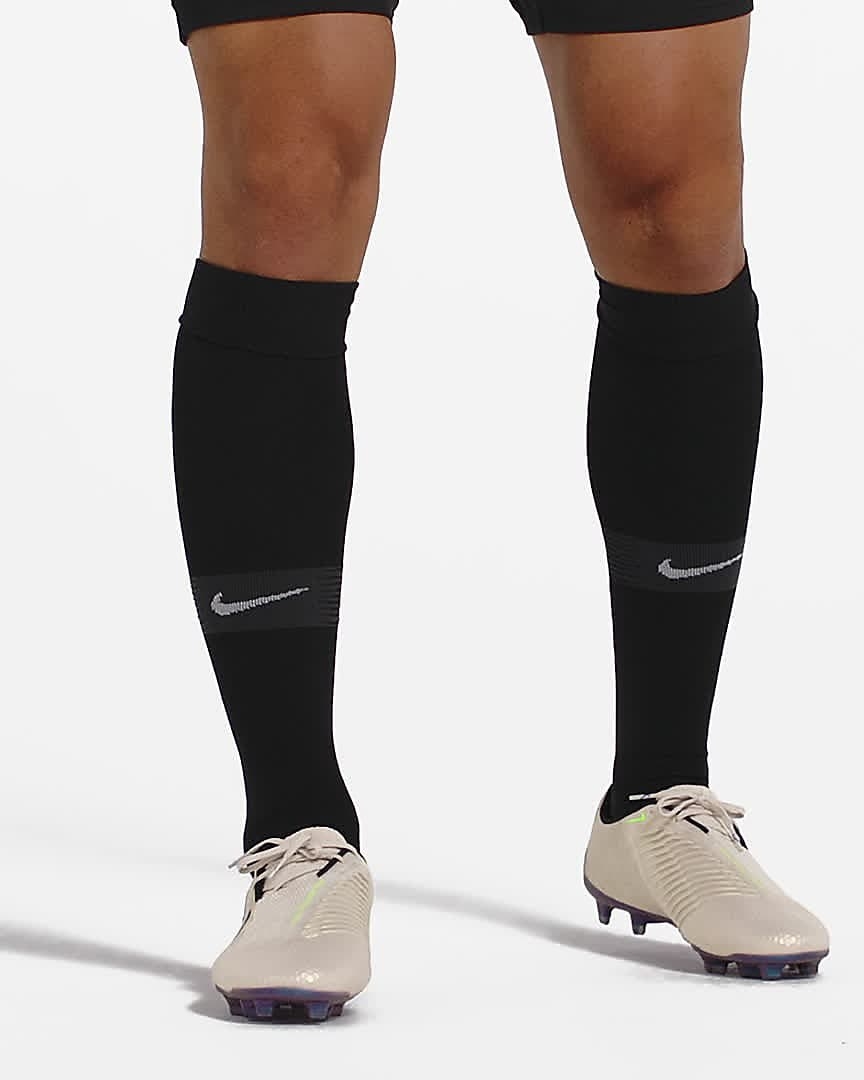 Model wears white Nike Venom Phantom Elite soccer cleats with high black socks