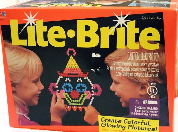 A orange Lite Brite box with two kids on the cover putting lights on a clown pattern