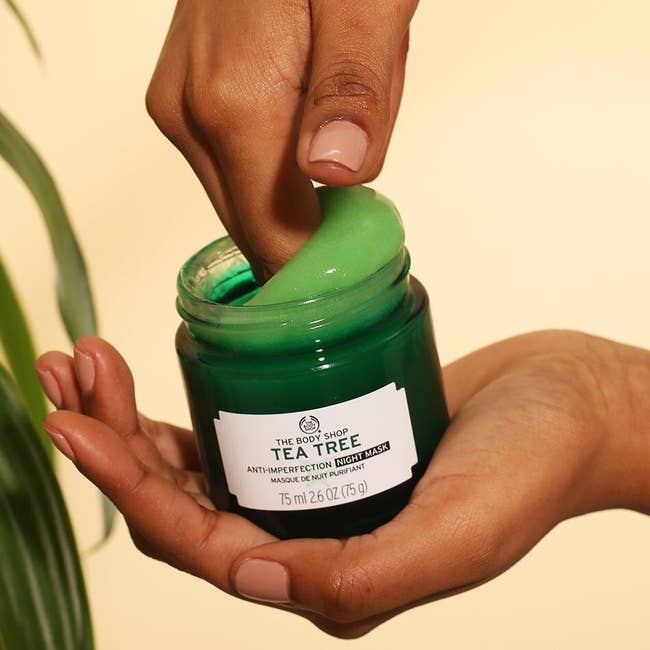 Hand digging into green jar of product
