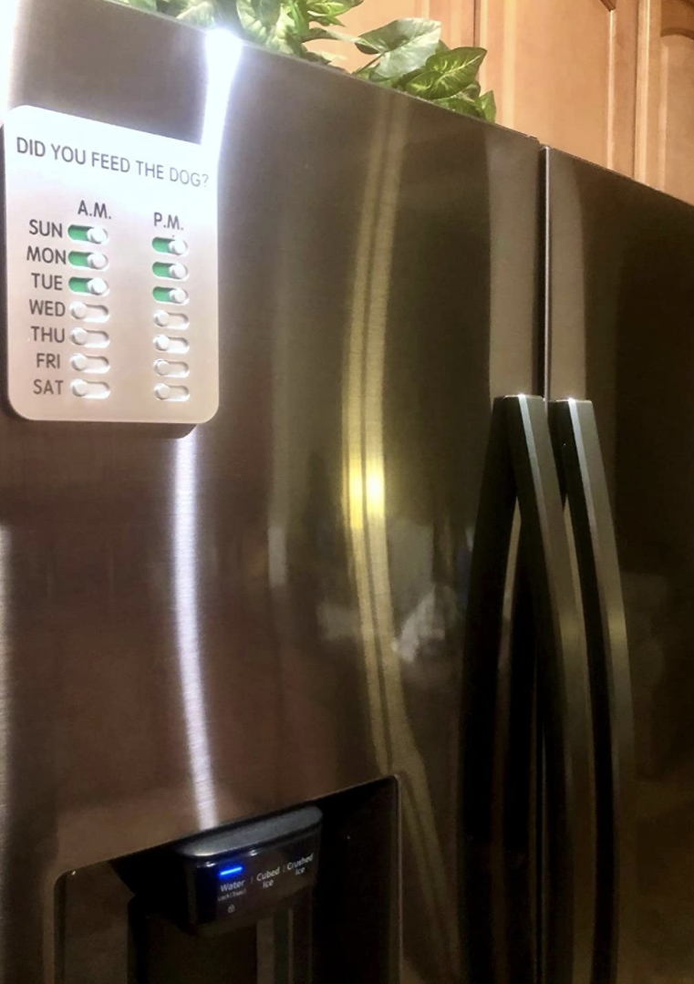 A reviewer photo of a refrigerator with the feeding tracker stuck to the front of it