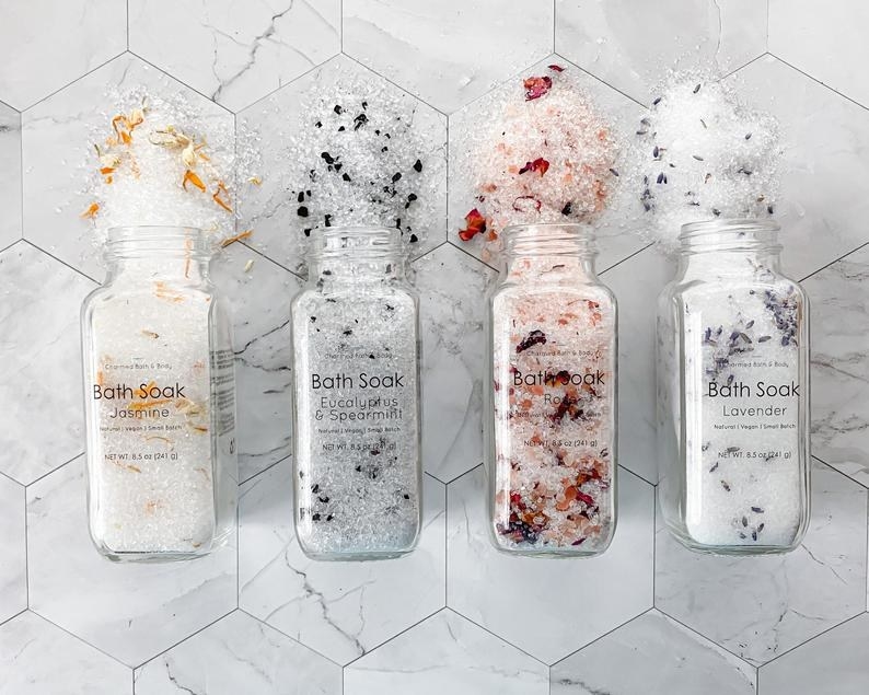 four different bottles pouring out bath salts