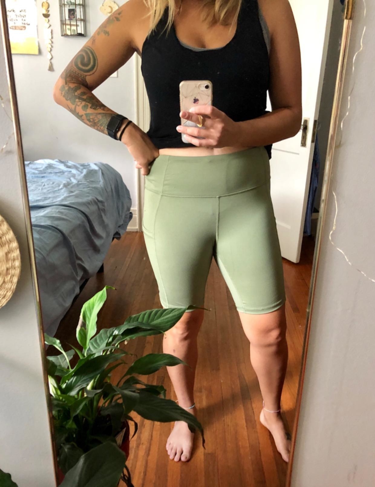 Reviewer wearing the high-waisted bike shorts in green