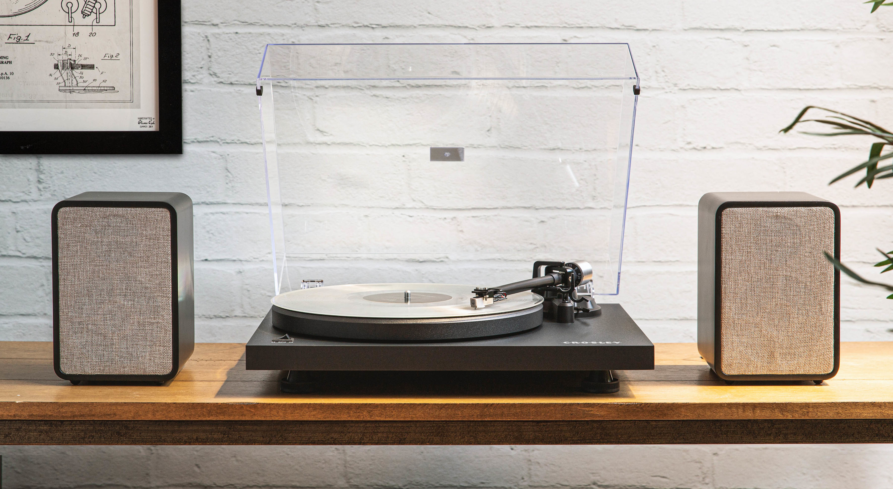 black turn table playing a vinyl record with two speakers next to the turntable