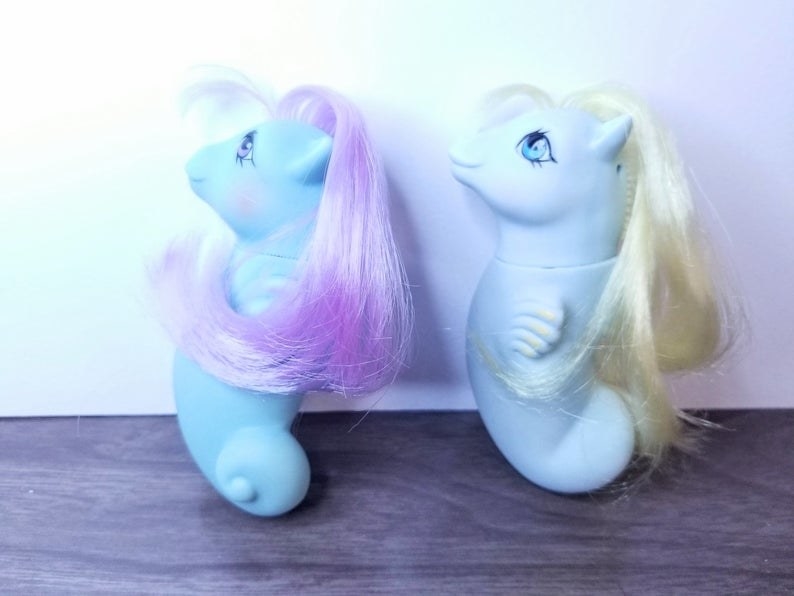Two baby blue My Little Pony sea horses one with lavender hair the other with yellow