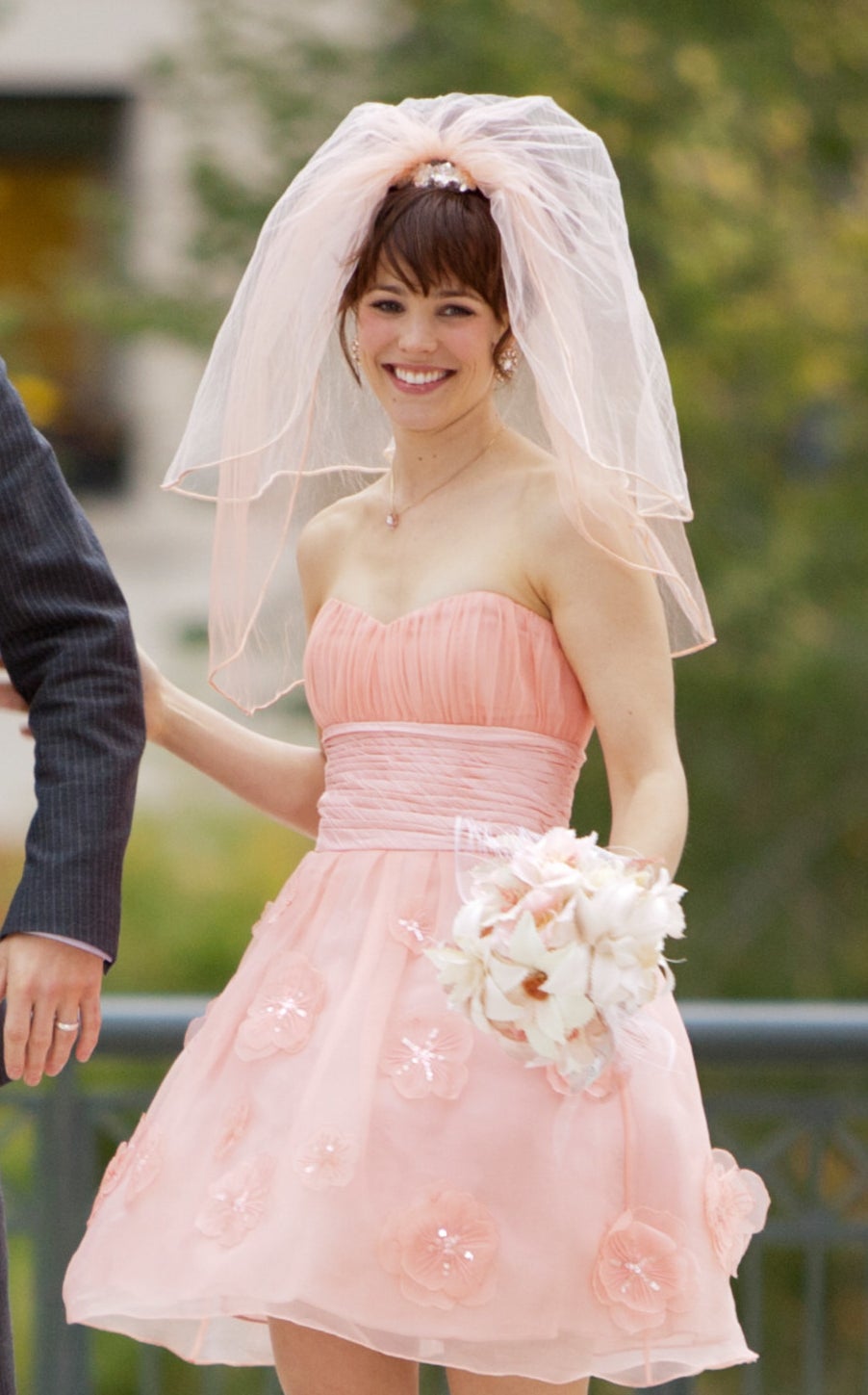 Paige in a short formal strapless dress with a sweetheart neckline, a thick band as the belt, and 3D flowers on the flare skirt