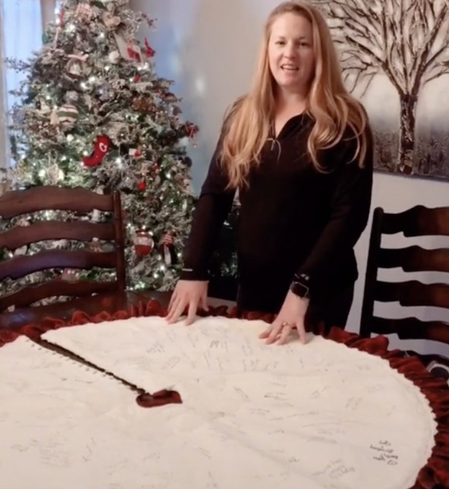 A bride shows off her tree skirt with signatures