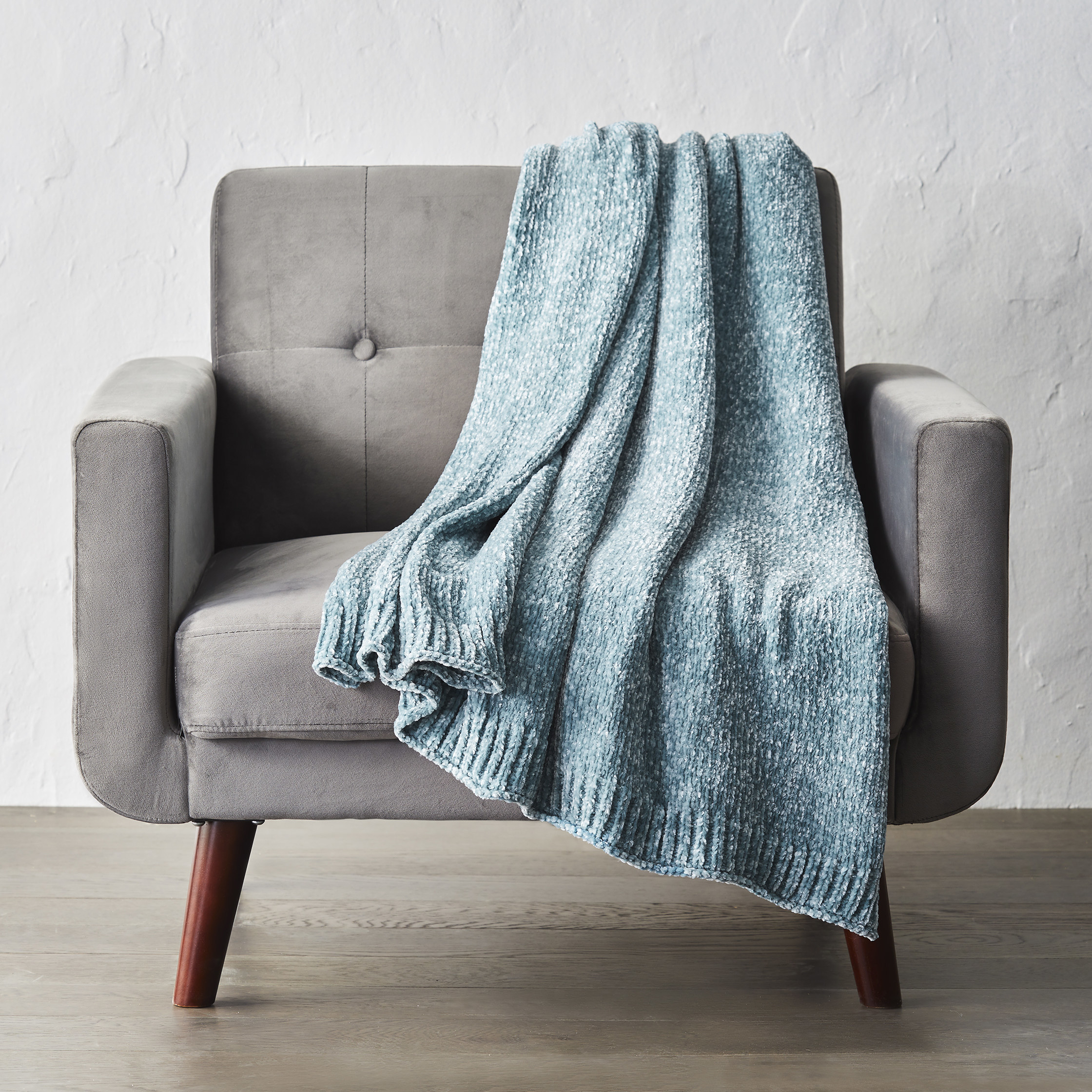 the throw in blue draped over a couch
