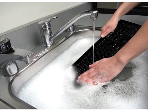 model cleaning keyboard in a sink with soap and water