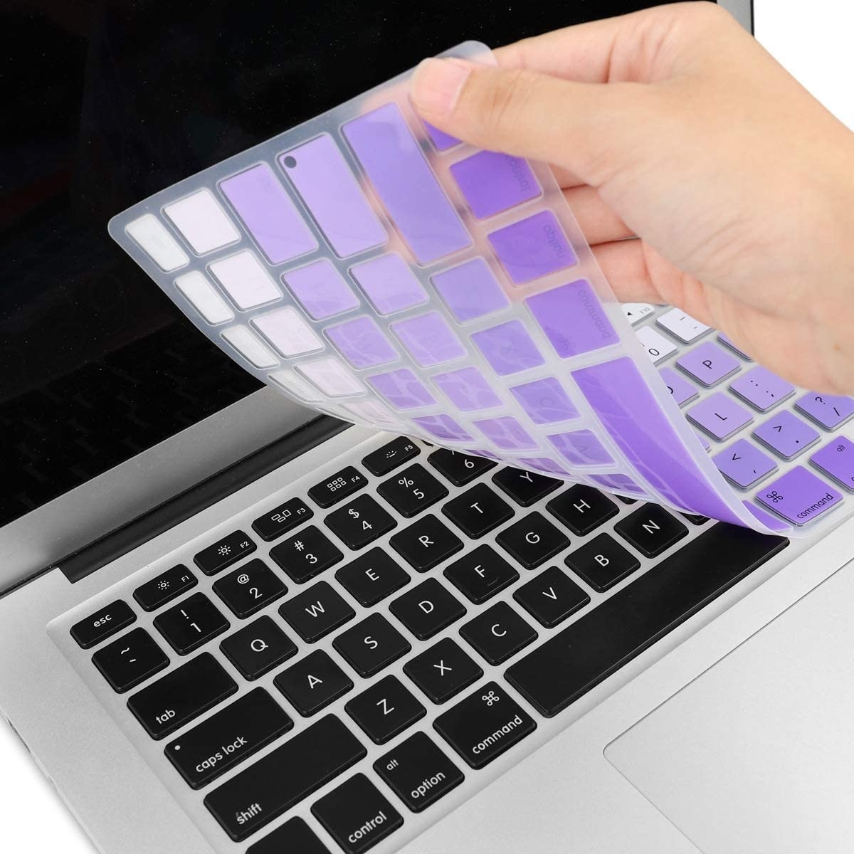 model placing purple keyboard cover onto laptop 